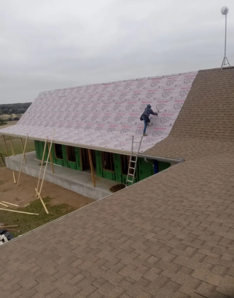 Worker preparing underlayment for a metal roof installation in Wisconsin Rapids